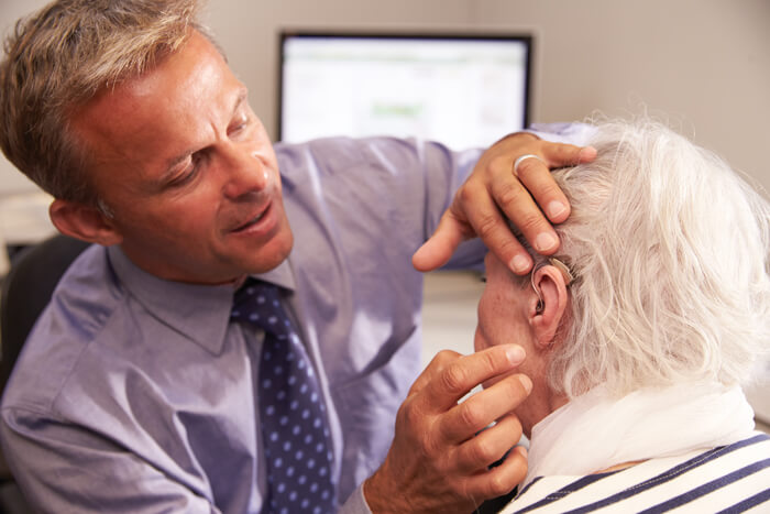 Photo showing ear examination of older patient.