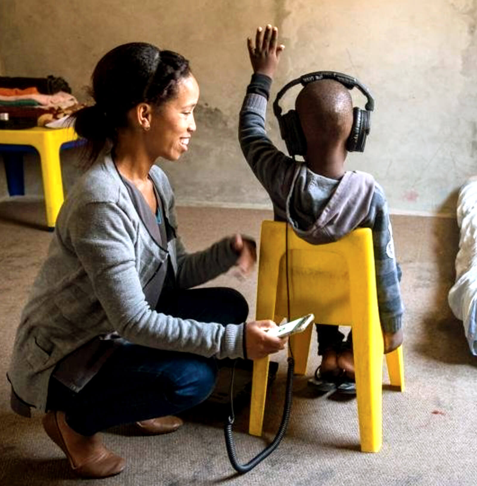 Photo showing lay health worker conducting hearing screening in Africa.
