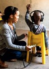 Photo showing lay health worker conducting hearing screening in Africa.