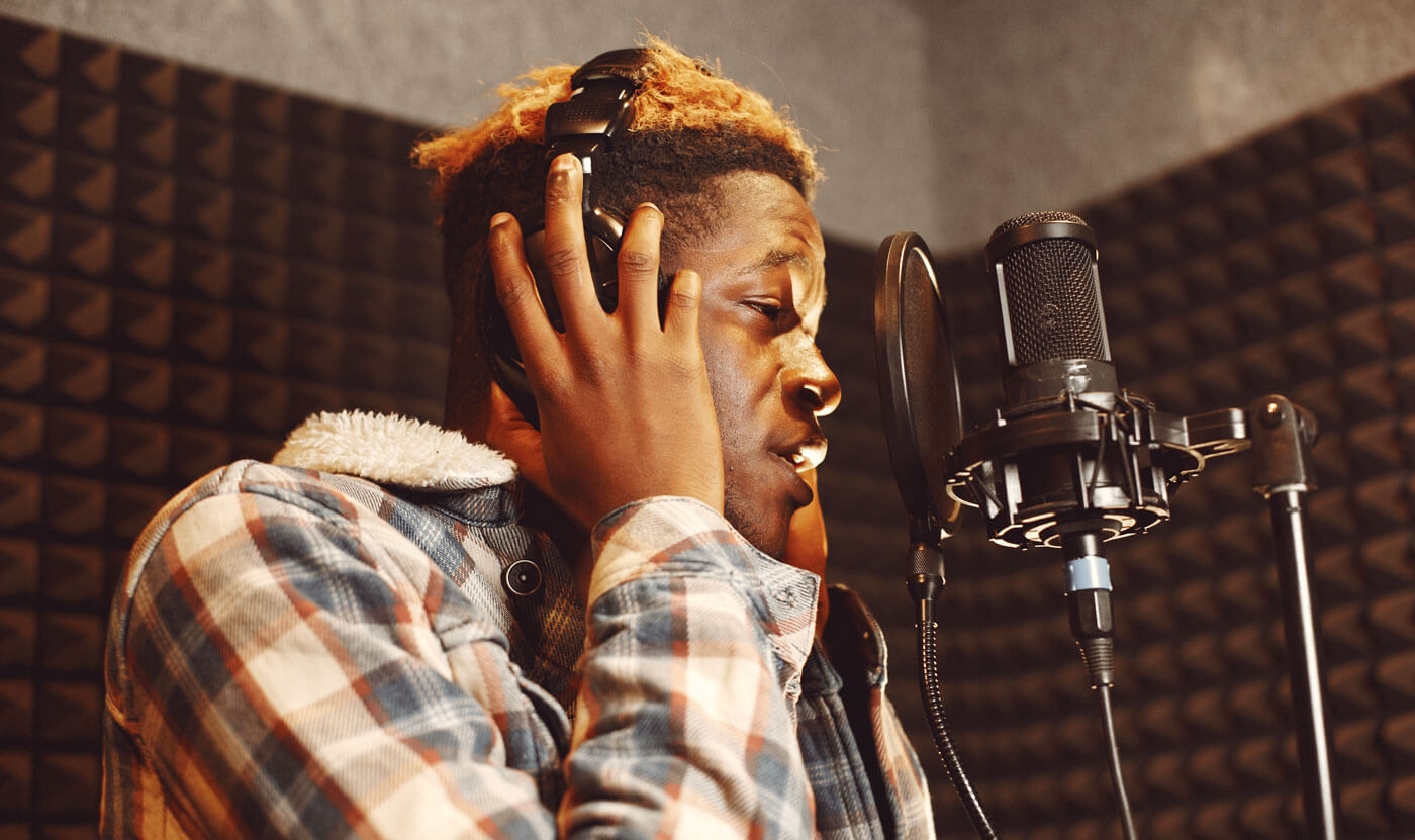 Photo of man singing in studio.