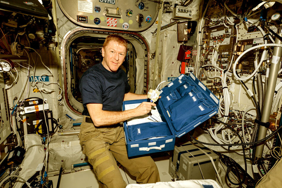 Photo showing how Tim Peake unpacks the CCFP/TMD Analyser in the Columbus module for the  NASA Fluid Shifts Experiment on the International Space Station.