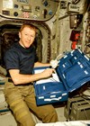 Photo showing how Tim Peake unpacks the CCFP/TMD Analyser in the Columbus module for the  NASA Fluid Shifts Experiment on the International Space Station.