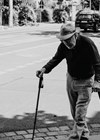 Photo of elderly man with walking sticks.