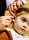 Photo of child receiving audiology treatment.
