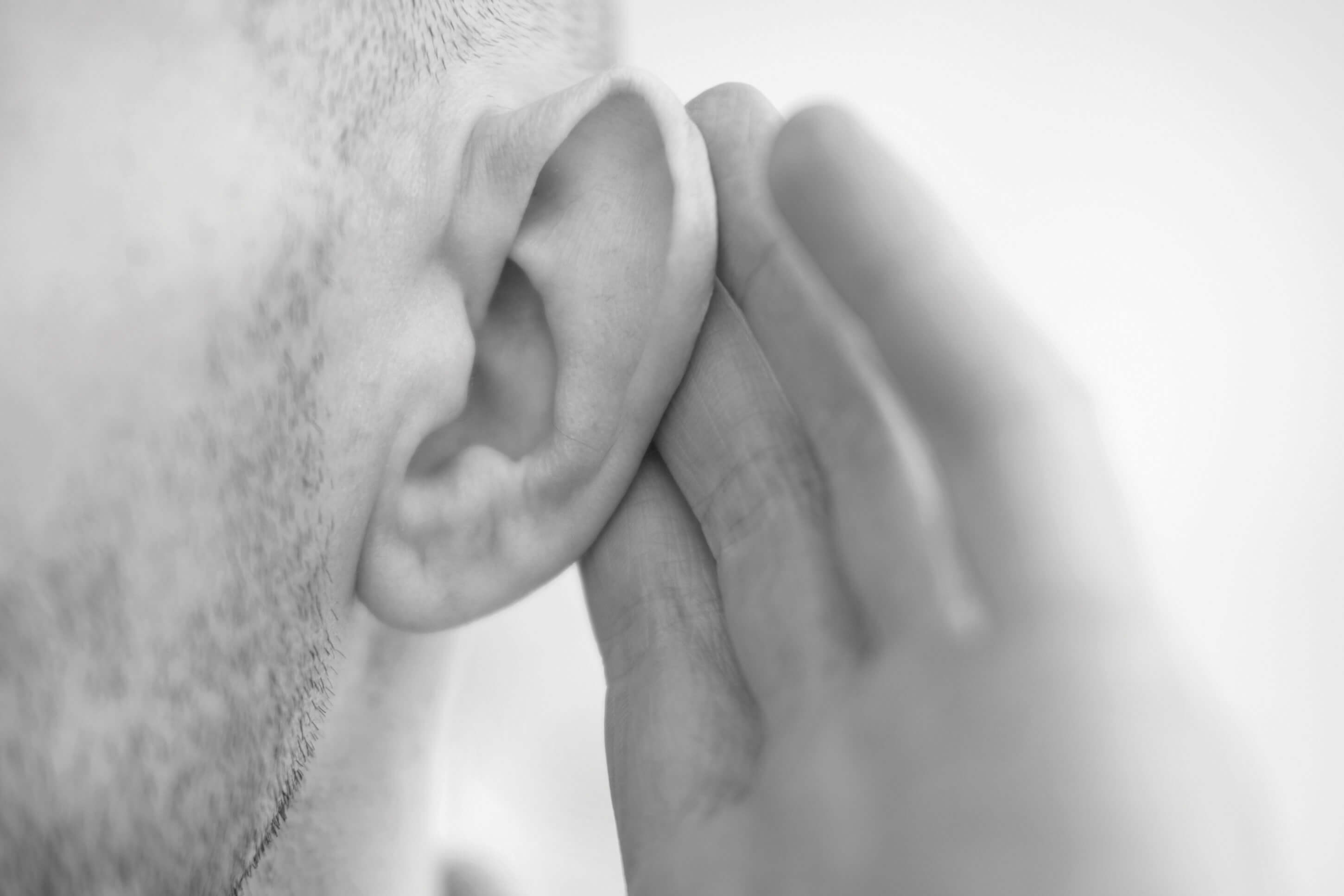 Photo showing person cupping ear to hear something.