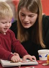 Photo of adult sitting beside child with hearing problems.