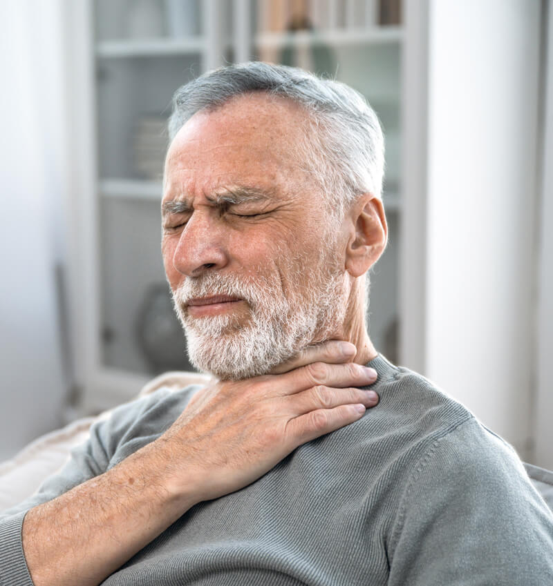 Photo of man holding this throat in pain. 