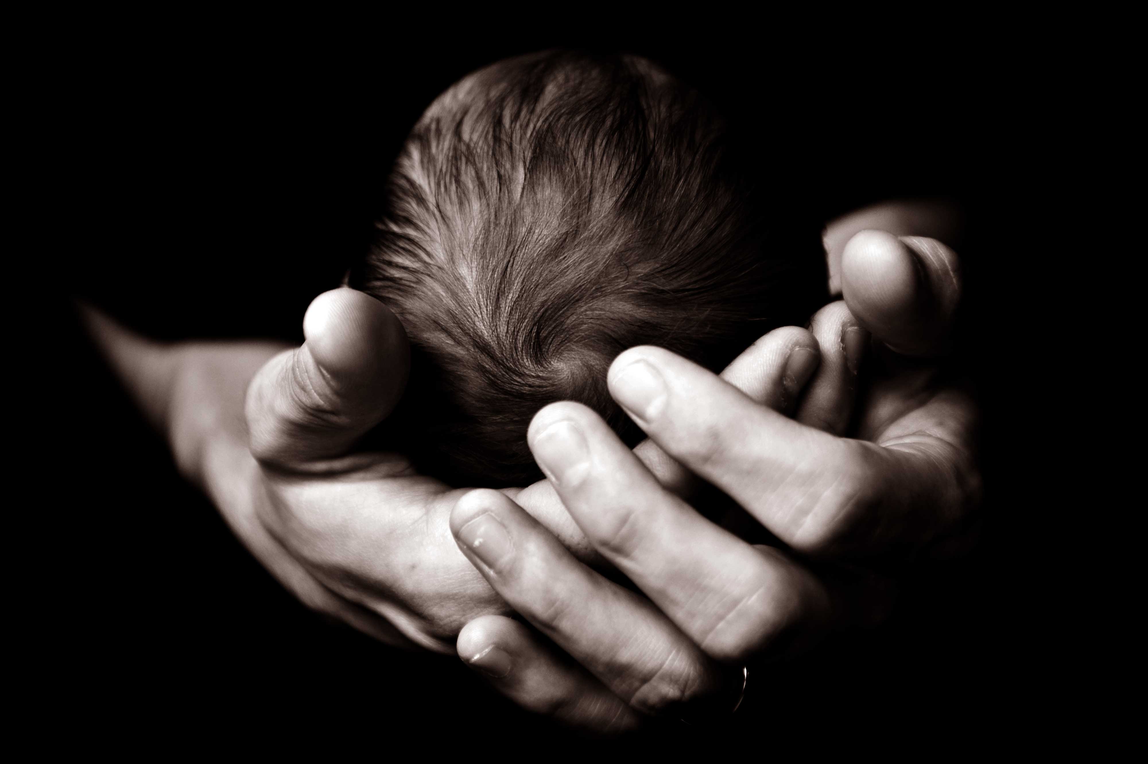 Image of baby in hands of adult.